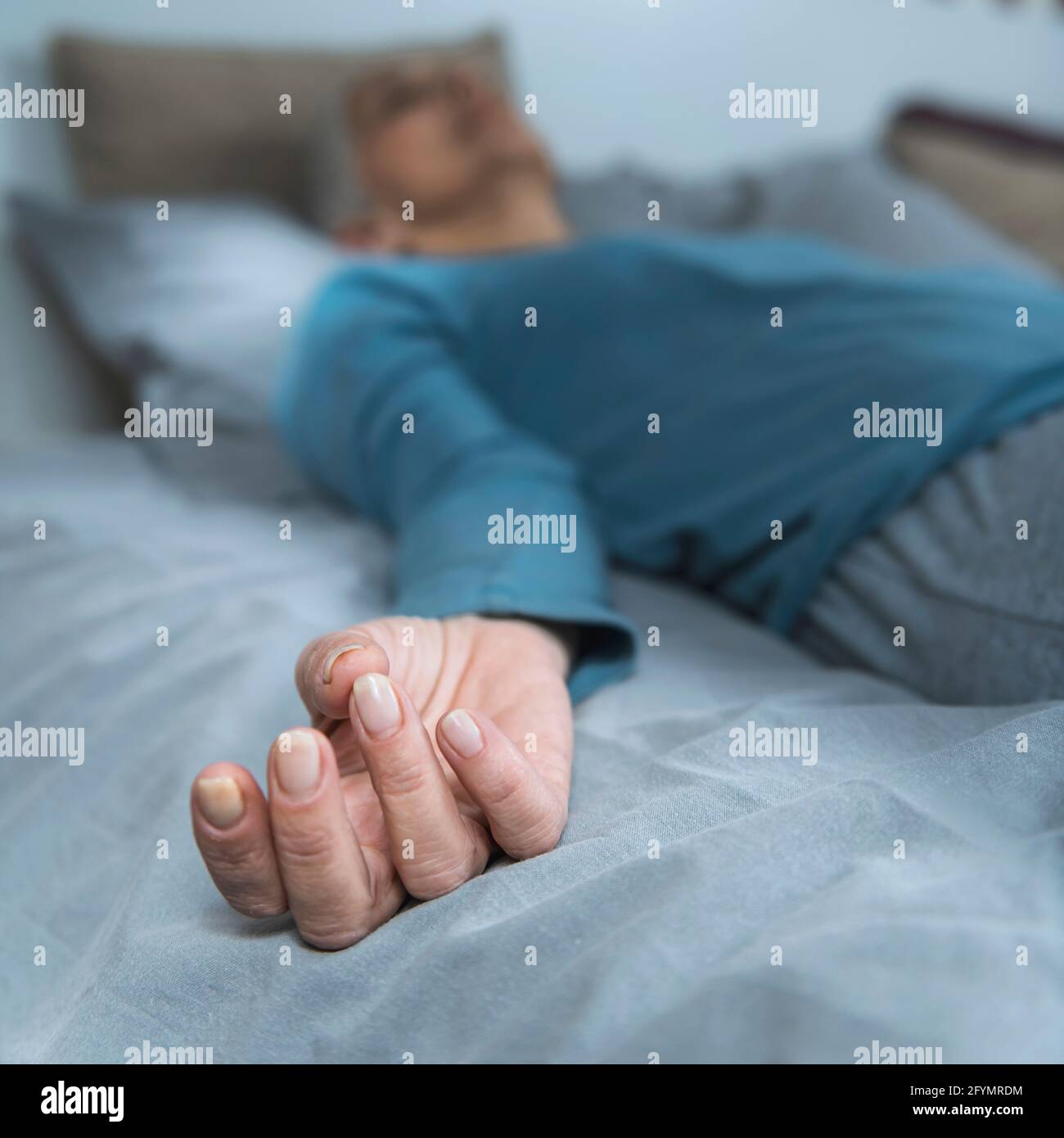 Woman lying in bed meditating Stock Photo