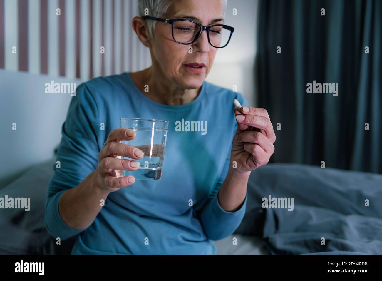 Woman taking melatonin pills Stock Photo