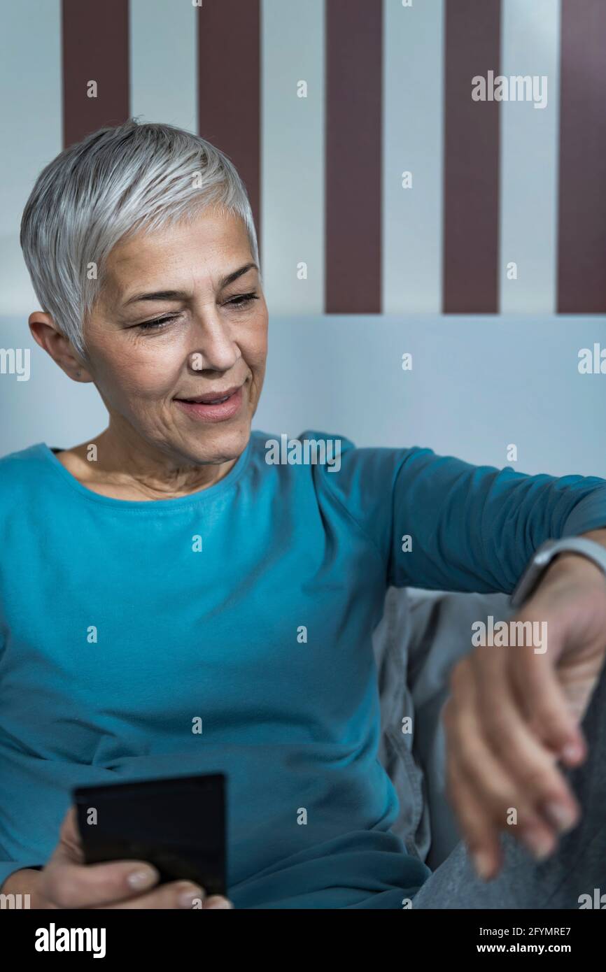 Senior woman checking smart watch sleep tracker Stock Photo