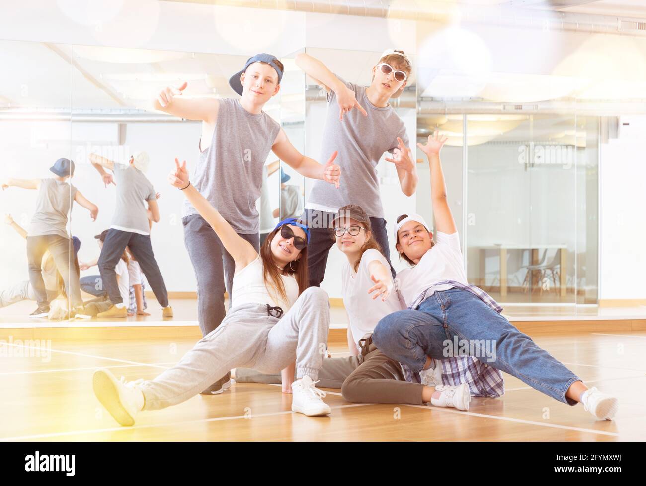 Group of dancing teenagers posing in dance studio. Hip hop dancers ...