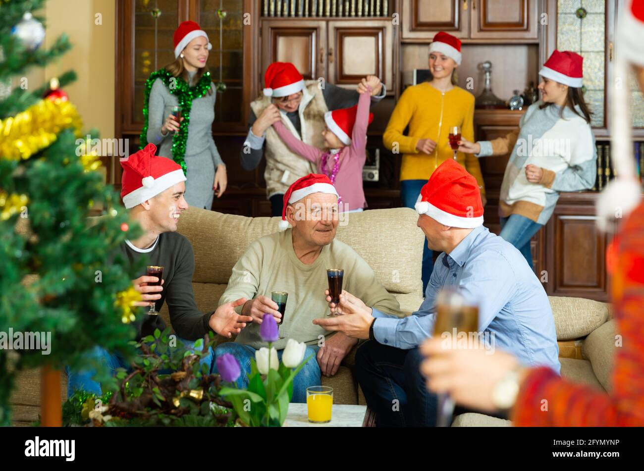 Members of big family spending time together on Christmas night at home Stock Photo