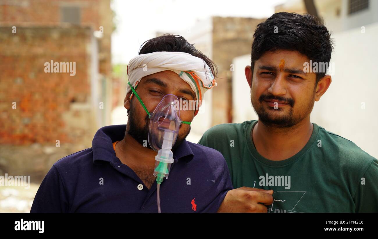 Jaipur, India - May 2021: Young Man infected with Corona Virus disease. Patient inhaling oxygen wearing mask with liquid Oxygen flow. Concept hospital Stock Photo