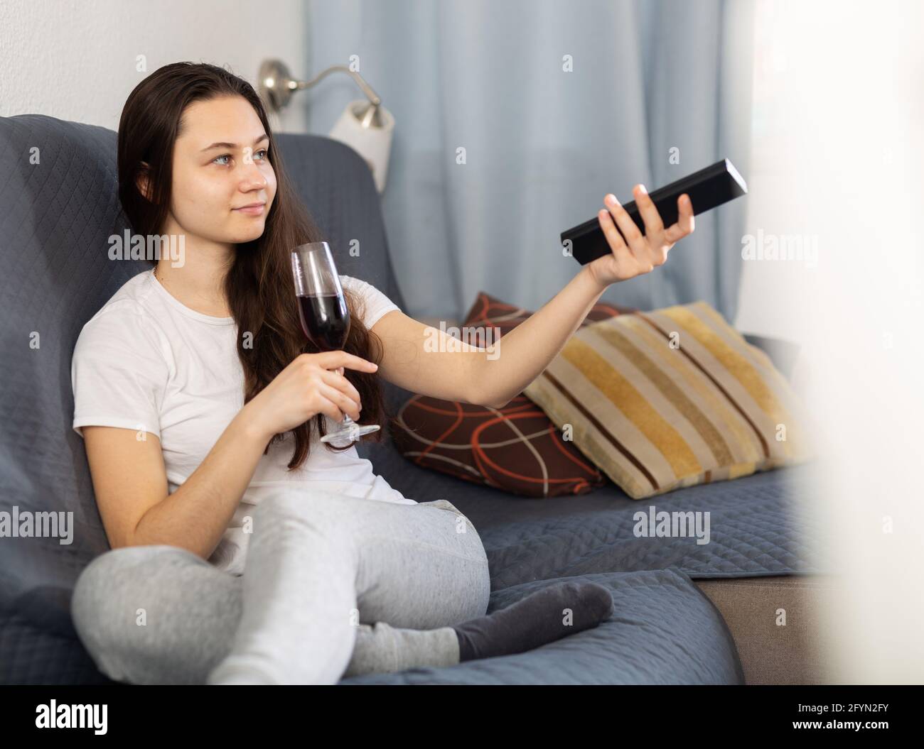 Young woman relaxing at evening with glass of red wine on sofa Stock ...