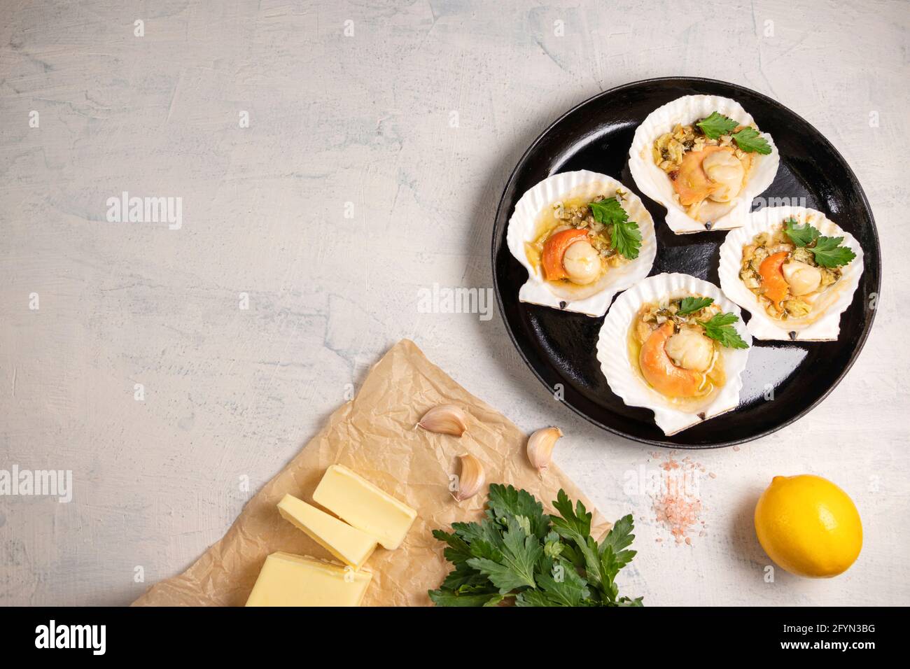 Top view onbaked scallops with caviar and creamy garlic sauce. Scallops, lemon, garlic, parsley, butter and salt. Recipe for cooking scallops with cav Stock Photo