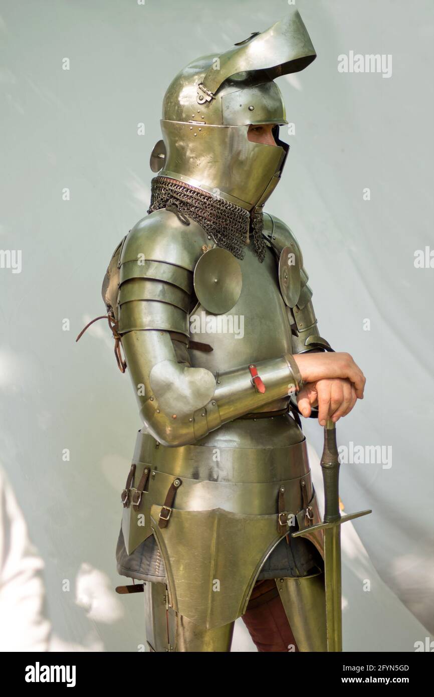 men with ancient helmet and sword. A vintage european full body armor suit isolated against white background. Stock Photo