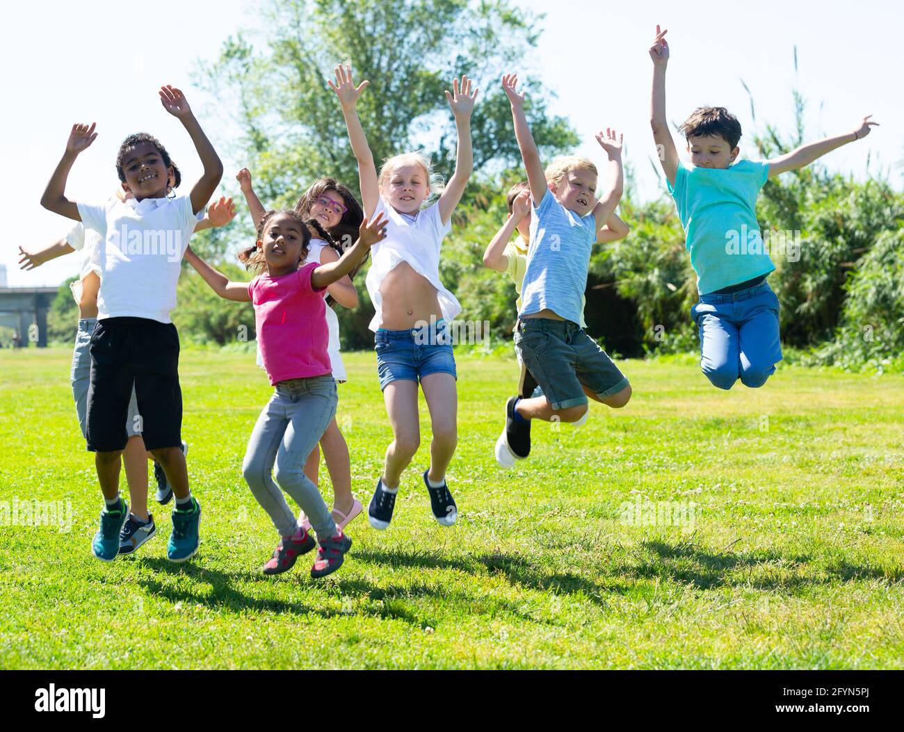Friendly kids jumping together in park on summer Stock Photo - Alamy