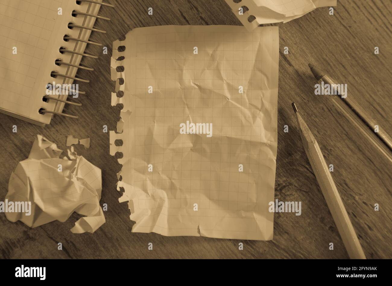 Crumpled empty pages and notebook lying on wooden surface Stock Photo
