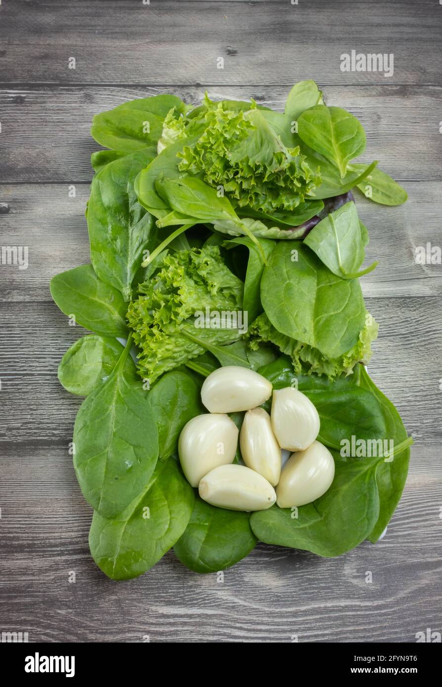 Heads of natural peeled garlic and green salad Stock Photo Alamy