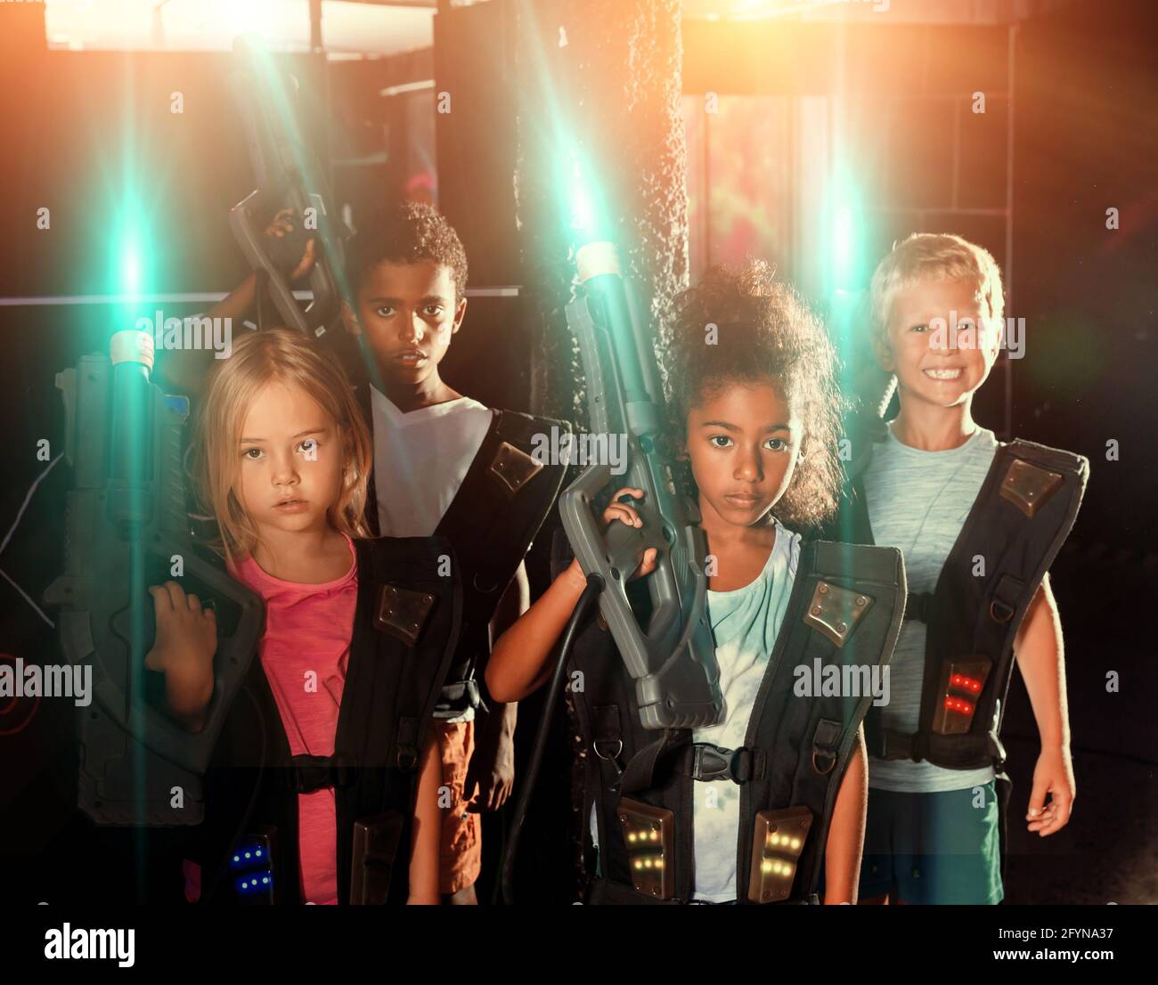 Portrait of multiracial group of happy preteen kids with laser guns ...