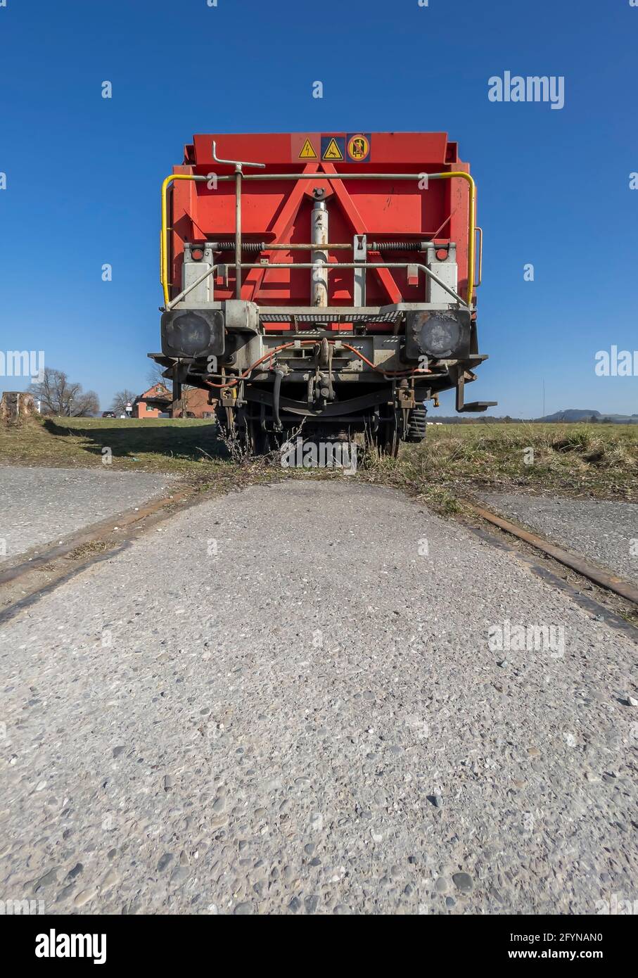 The last wagon of a standing train composition on a track in the middle of a meadow Stock Photo