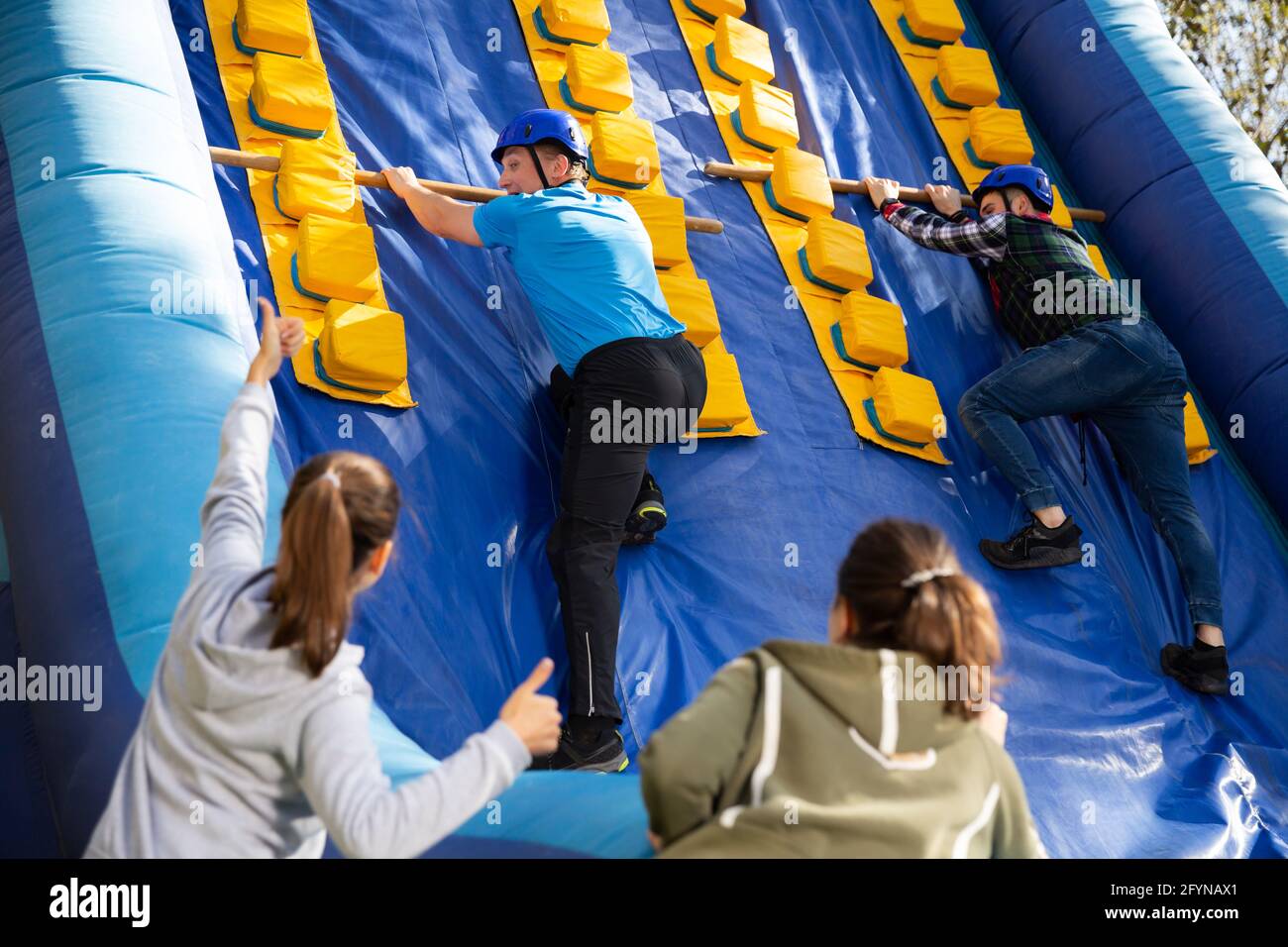 Group of enthusiastic men and women passing obstacles and having fun on ...
