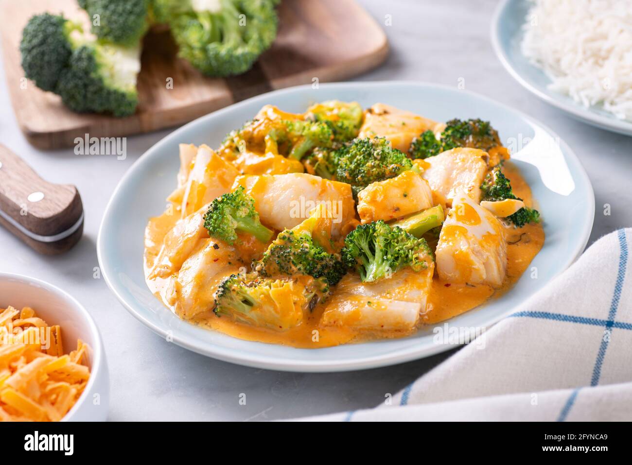 Delicious oven baked fish with broccoli and cheddar cheese. Stock Photo