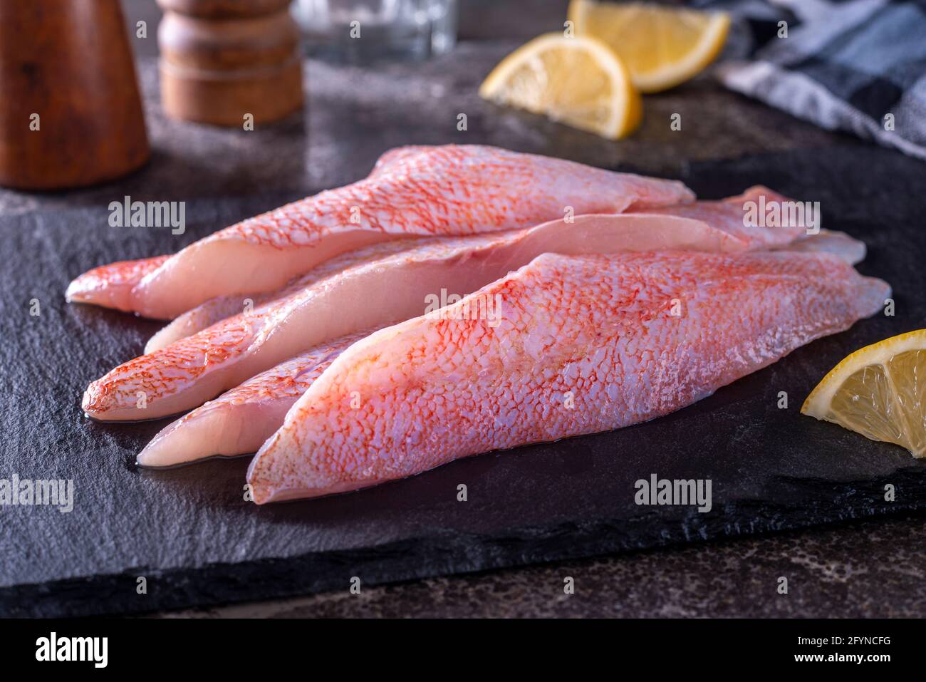 Fresh ocean perch Acadian redfish fillets on a slate board. Stock Photo
