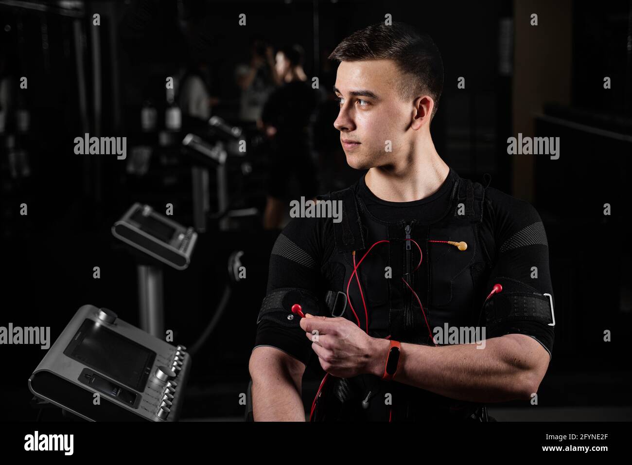 Man with electronic contactor of EMS suit in gym. Sport training in electrical muscle stimulation suit Stock Photo