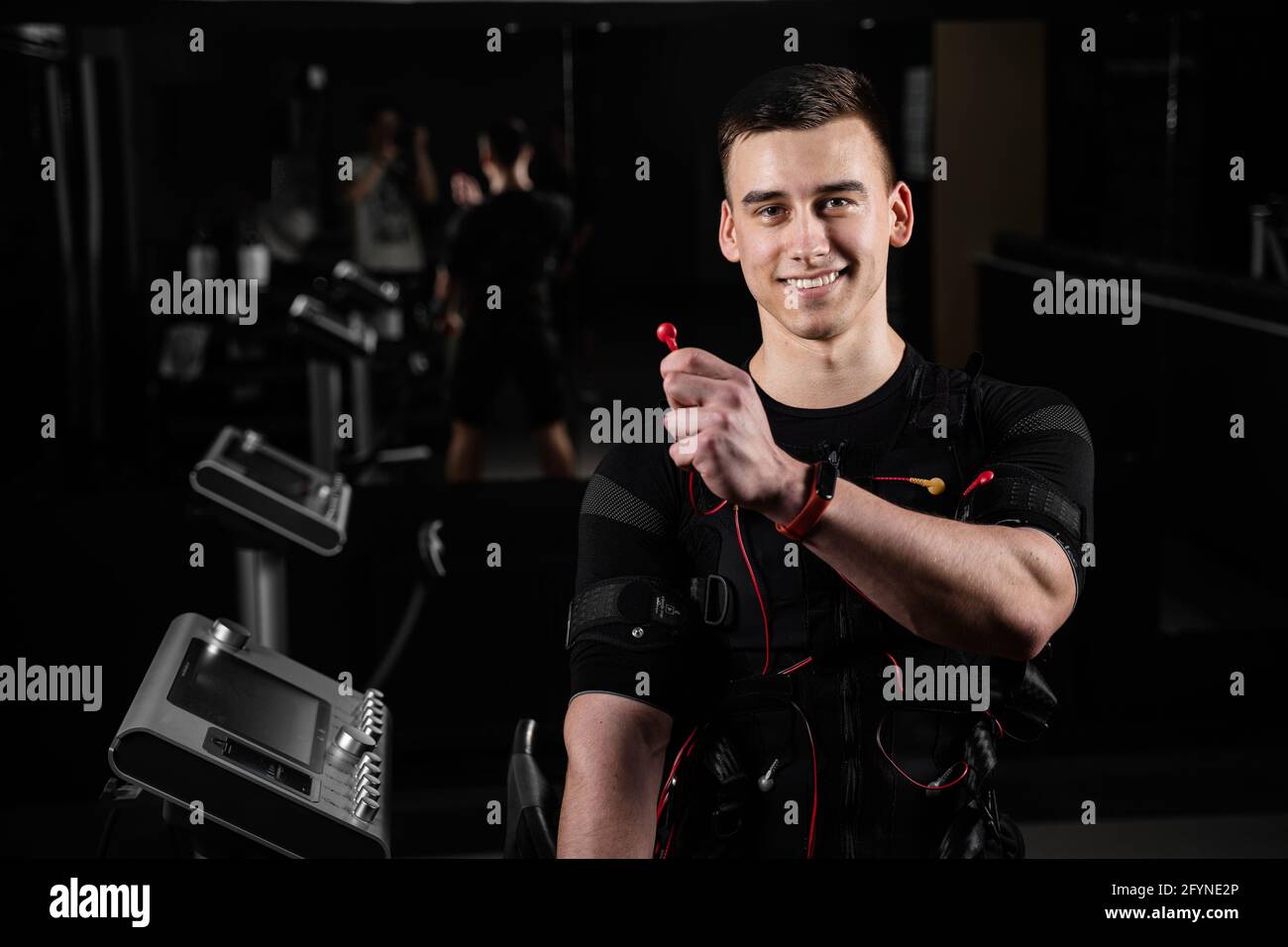 Man with electronic contactor of EMS suit in gym. Sport training in electrical muscle stimulation suit Stock Photo