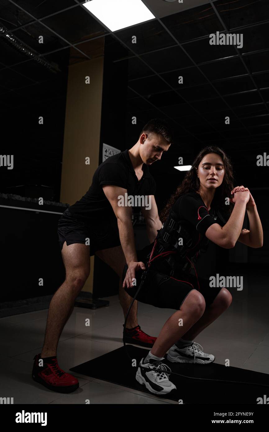 https://c8.alamy.com/comp/2FYNE9Y/man-trainer-trains-a-girl-in-an-ems-suit-in-the-gym-electrical-stimulation-of-the-misc-during-active-training-2FYNE9Y.jpg