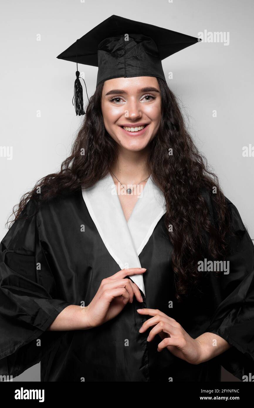 Graduate girl with master degree in black graduation gown and cap on white  background. Happy young woman careerist have success in her business Stock  Photo - Alamy