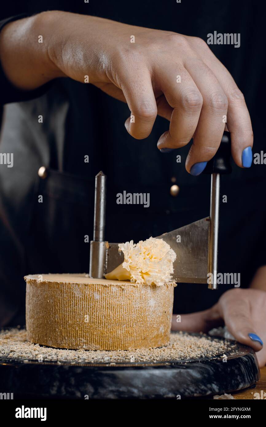 https://c8.alamy.com/comp/2FYNGXM/shaving-tete-de-moine-cheese-using-girolle-knife-monks-head-variety-of-swiss-semi-hard-cheese-made-from-cows-milk-2FYNGXM.jpg
