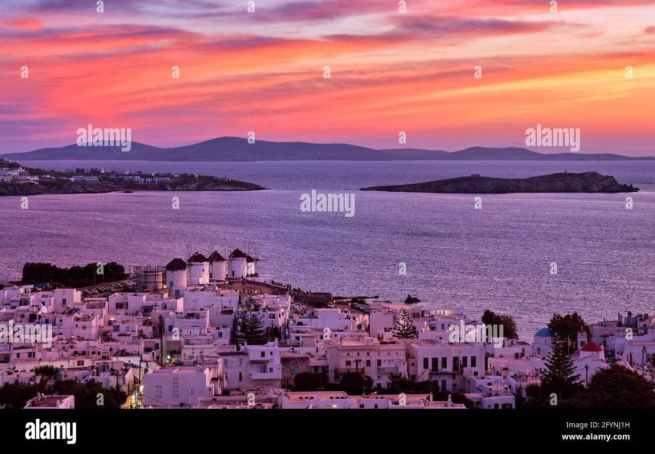 Beautiful sunset view, famous traditional white windmills on hilltop, Mykonos, Greece. Whitewashed house, summer, iconic Mediterranean destination Stock Photo