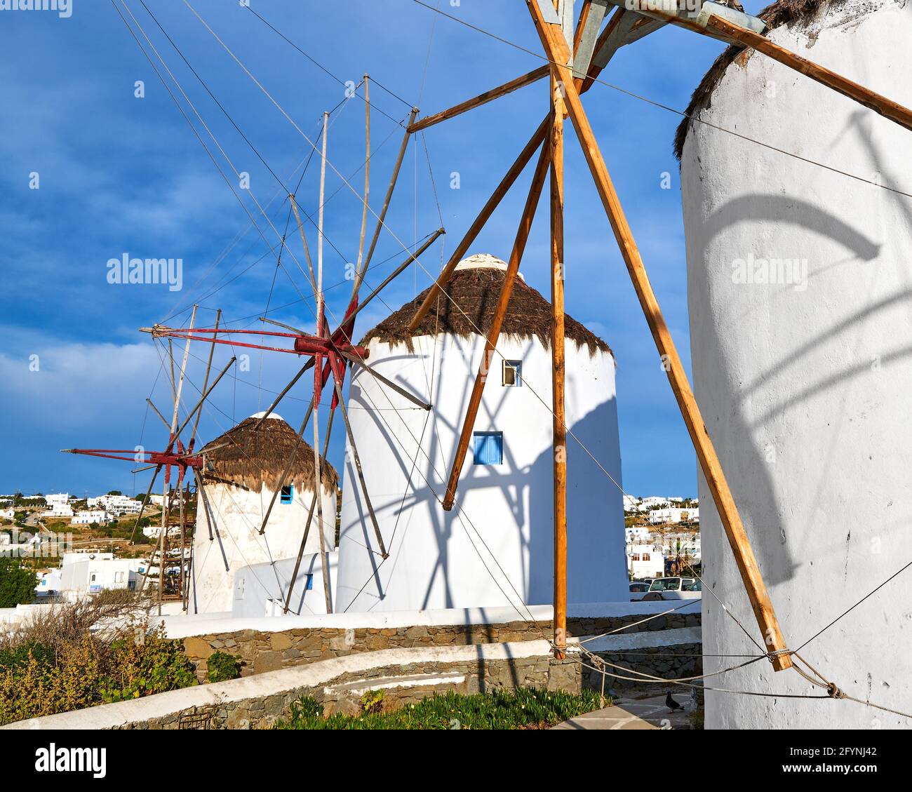 Famous tourist attraction of Mykonos, Greece. Traditional whitewashed windmills, summer, blue sky, beautiful clouds. Travel destination, iconic view. Stock Photo