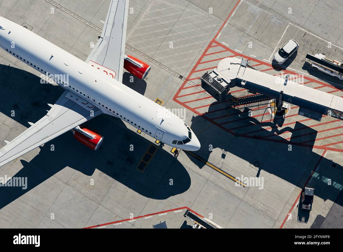 Aerial view of plane. Airplane in front of the passenger boarding bridge from airport terminal. Stock Photo