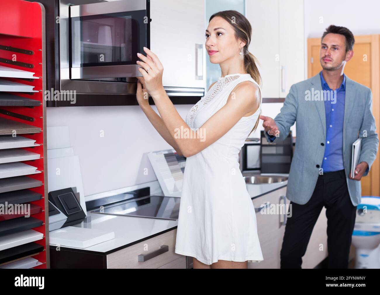 Happy assistant working with customer in kitchen furniture store Stock ...