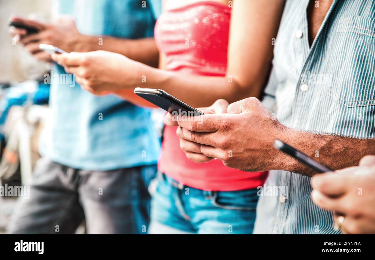 Cropped view on milenial hands using mobile smartphones - People addicted by smart phones - Technology concept with always connected teenagers Stock Photo