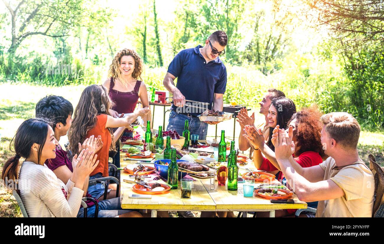 Happy friends having fun together at barbecue picnic party - Young people millenials at pic nic on open air festival - Youth friendship concept Stock Photo