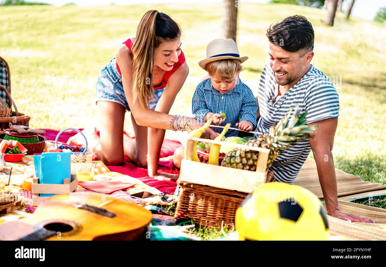 Happy family having fun together at picnic party - Joy and love life style concept with mother and father playing with child at park Stock Photo
