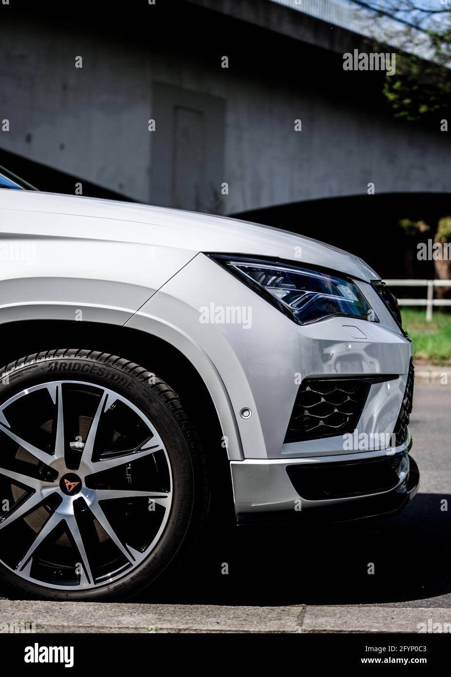 Vertical shot of the front part of a new white car parked in a street ...