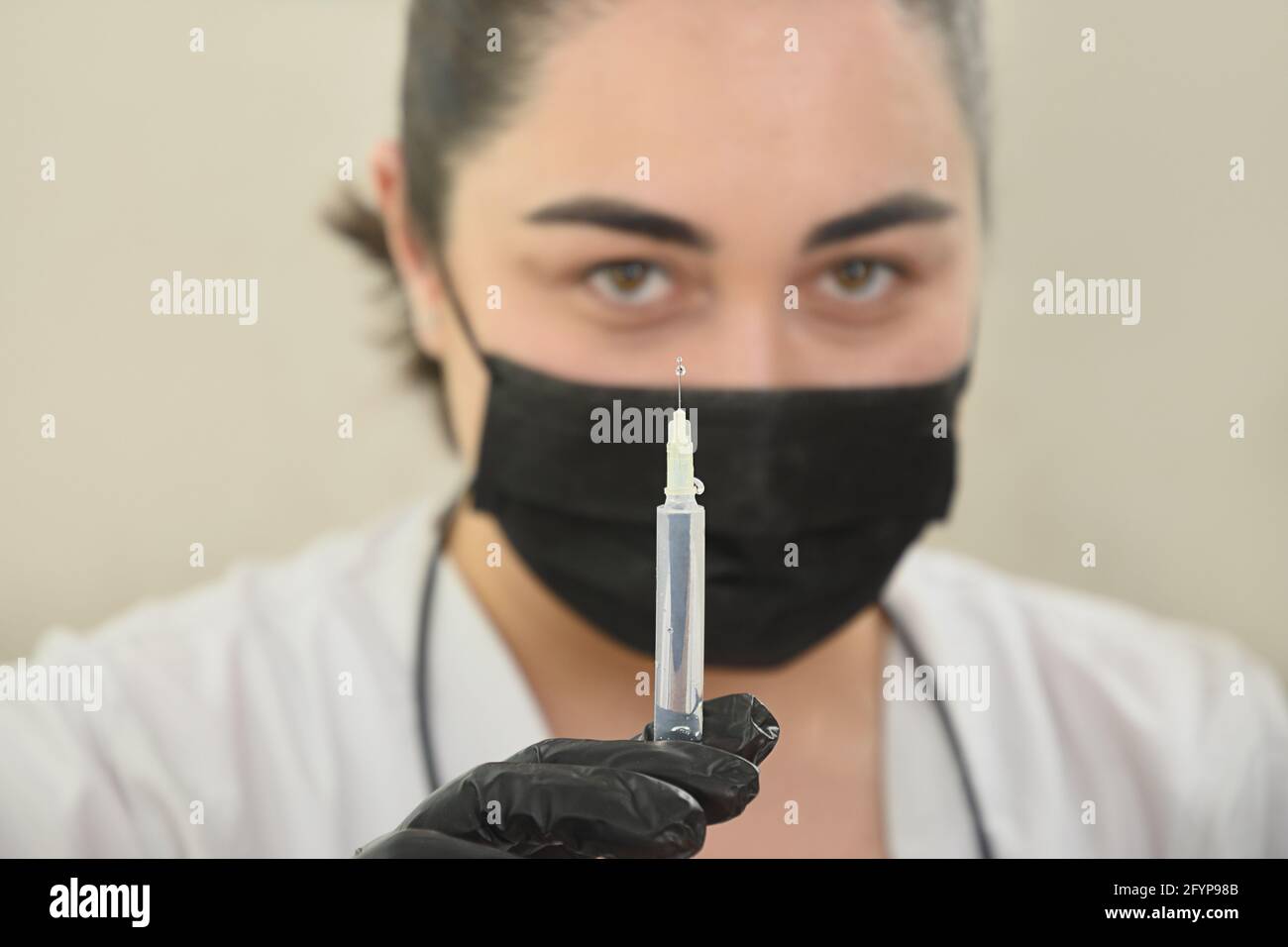Doctor holds and prepares a syringe for medical procedure or beauty injection. Stock Photo