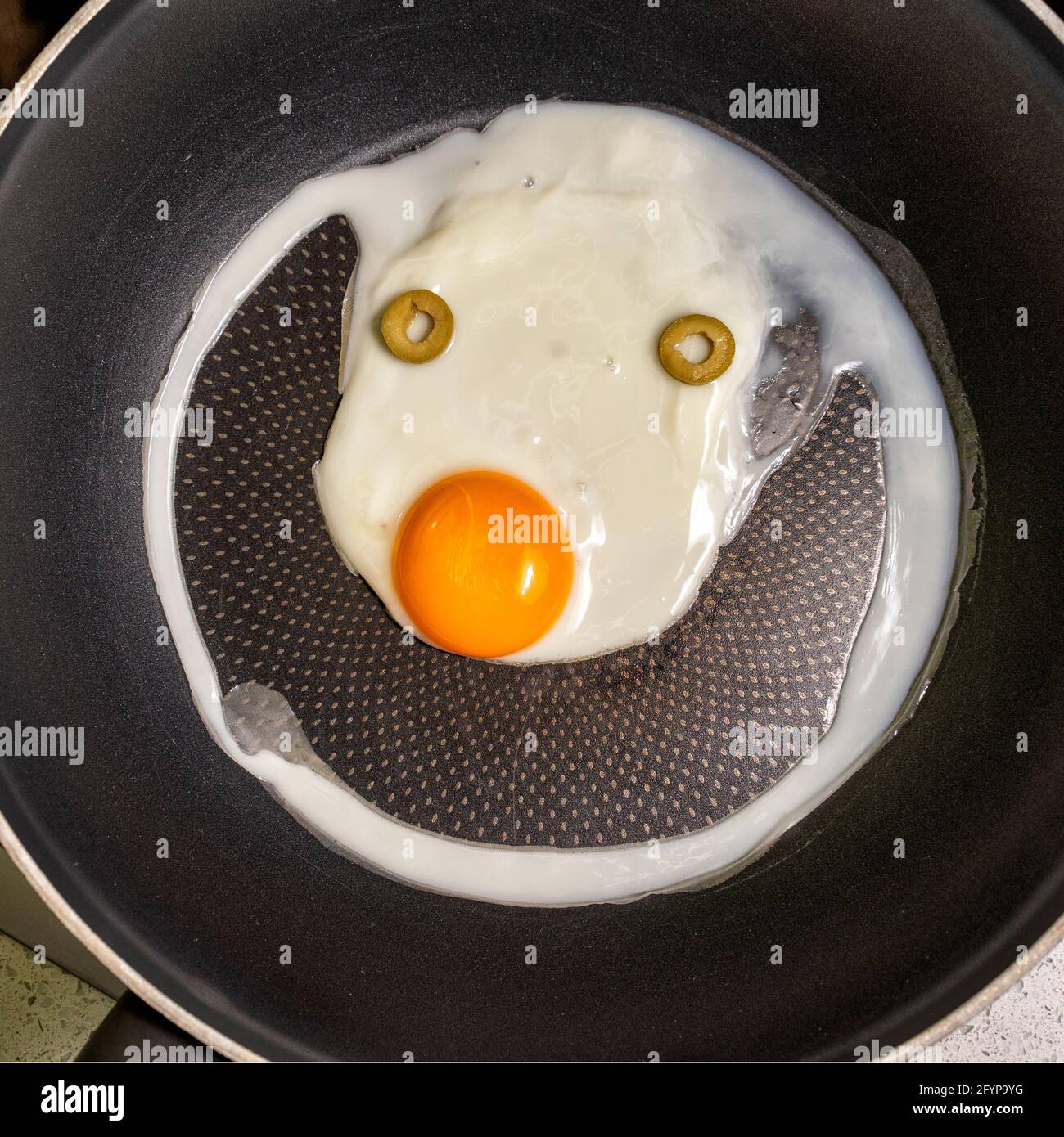 scrambled eggs in a frying pan with a funny face with a smile Stock