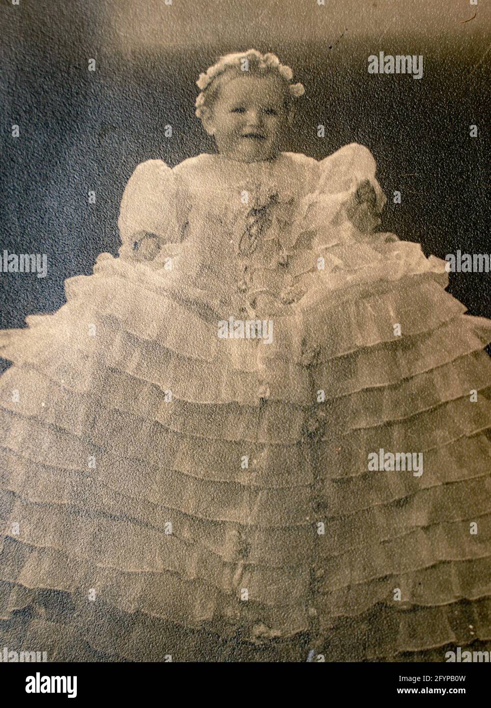 Germany- CIRCA 1930s: Portrait of baby girl wearing baptism dress in studio. Vintage archive Art Deco era photography Stock Photo