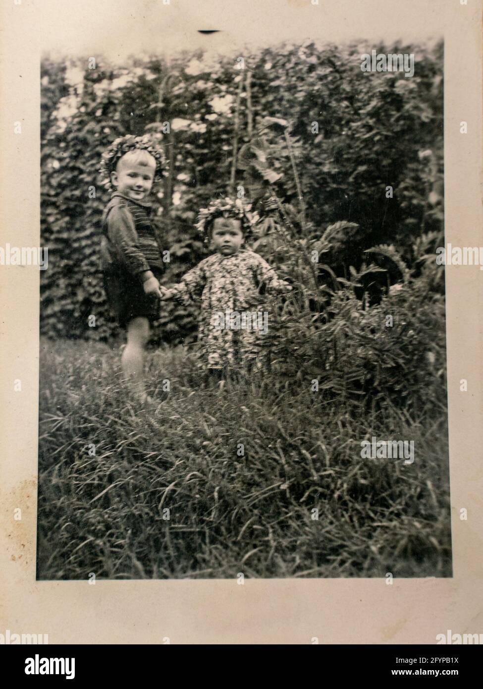 Germany - CIRCA 1930s: Photo of two small kids standing in garden at summer. Vintage archive Art Deco era photography Stock Photo