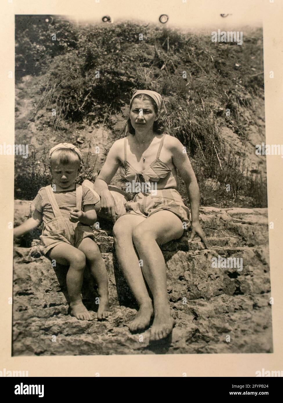 Germany - CIRCA 1930s: Mother and small kid sitting in beach. Vintage archive Art Deco era photography Stock Photo