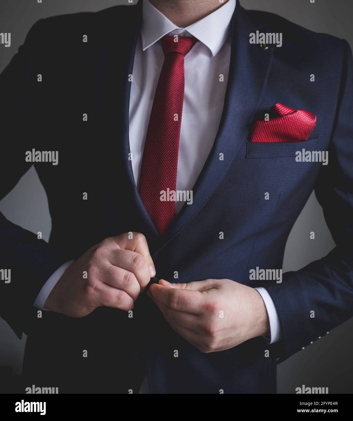 Man In A Blue Suit And Red Tie Buttoning His Suit Jacket Stock Photo - Alamy