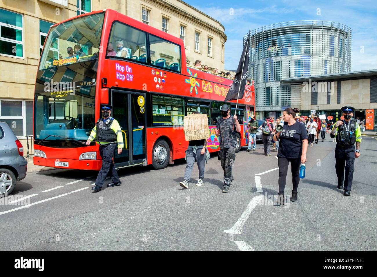Bath, Somerset, UK. 29th May, 2021. Passengers on a sightseeing Bus look on as 'Kill the bill' protesters carrying anti government placards and signs take part in a kill the bill protest march through the centre of Bath. The protesters took to the streets to demonstrate about the police, crime, sentencing and courts bill which the UK government wants to bring into force.The bill includes major government proposals on crime and justice in England and Wales. Credit: Lynchpics/Alamy Live News Stock Photo