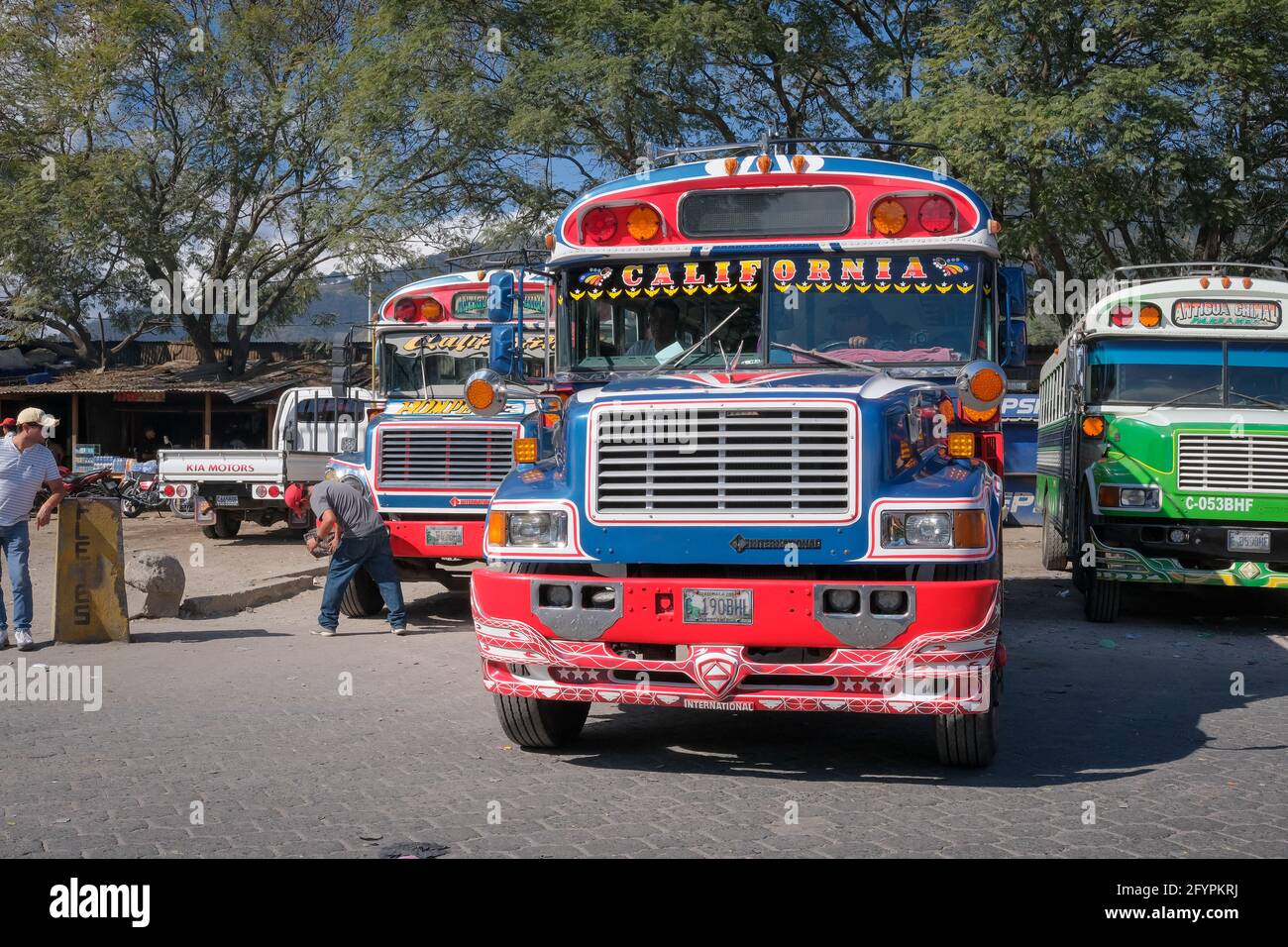 Colourful Guatemalan 'chicken buses' await passengers at the bus terminal in Antigua Guatemala Stock Photo