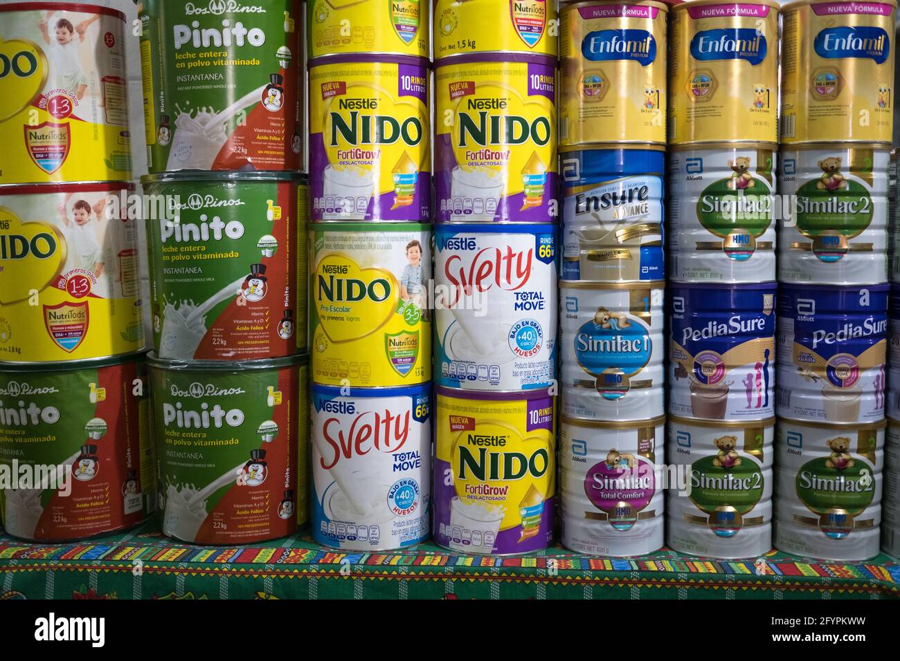 Tins of dried milk products for infants stacked up for sale in the main market of Antigua Guatemala Stock Photo