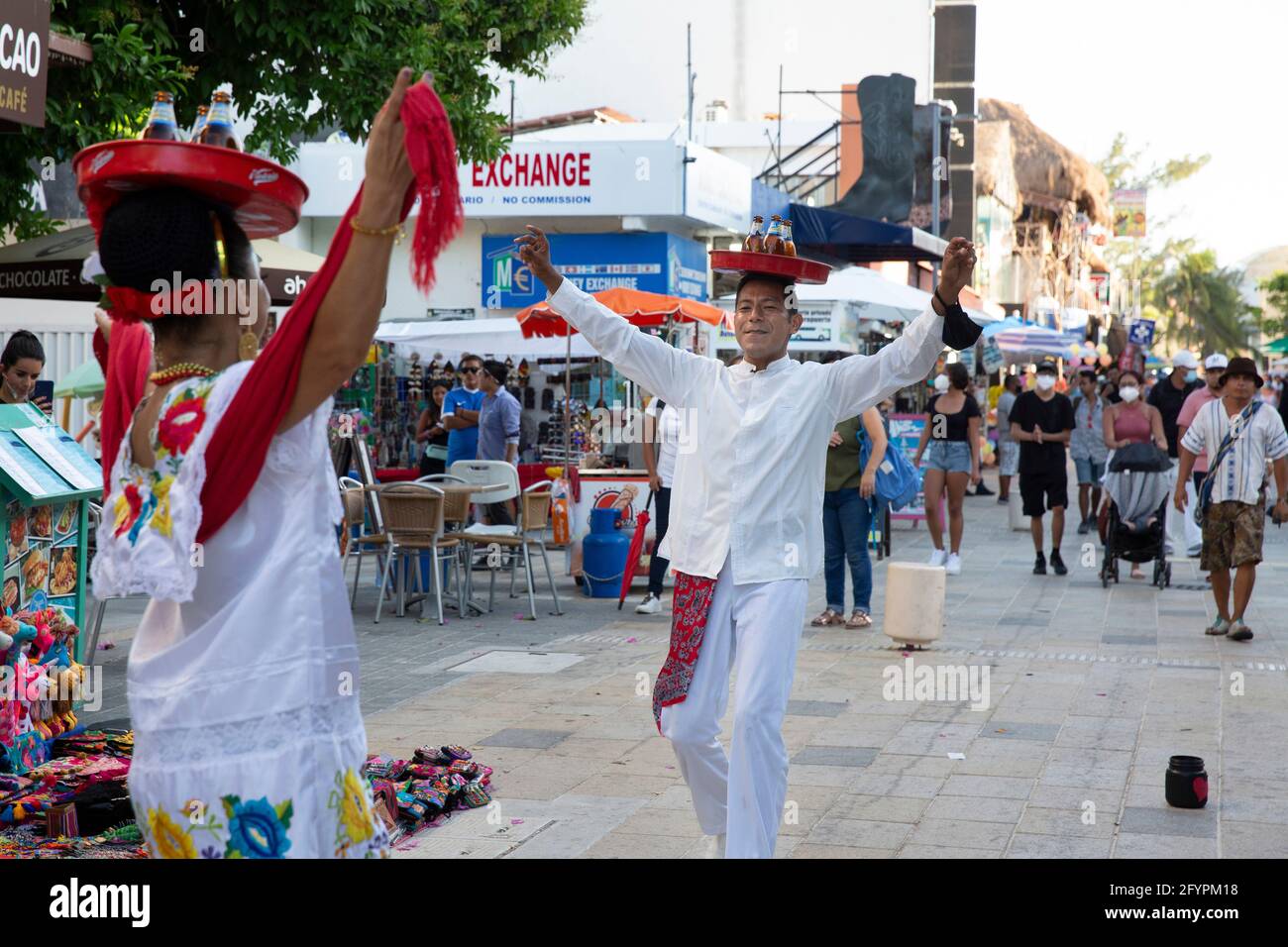 Bernardo Coca (R) and a dancer perform on the 5th Avenue amid the coronavirus pandemic in Playa del Carmen, Quintana Roo state, Mexico, on April 30, 2021. Bernardo and his colleagues lost their jobs in the entertainment industry during the coronavirus outbreak in March 2020. As they remain unemployed, they are forced to perform on the streets to make a living. Mexico is one of the countries hardest hit by the pandemic. The state of Quintana Roo has confirmed nearly 26,000 positive cases. Limited testing means actual numbers are likely far higher. And even as tourists flock the Riviera Maya, of Stock Photo