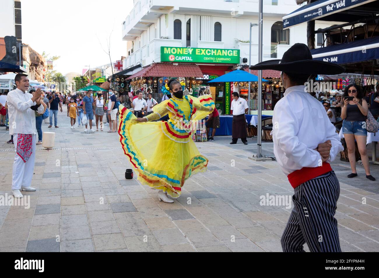 Bernardo Coca (L) and two dancers perform on the 5th Avenue amid the coronavirus pandemic in Playa del Carmen, Quintana Roo state, Mexico, on April 30, 2021. Bernardo and his colleagues lost their jobs in the entertainment industry during the coronavirus outbreak in March 2020. As they remain unemployed, they are forced to perform on the streets to make a living. Mexico is one of the countries hardest hit by the pandemic. The state of Quintana Roo has confirmed nearly 26,000 positive cases. Limited testing means actual numbers are likely far higher. And even as tourists flock the Riviera Maya, Stock Photo