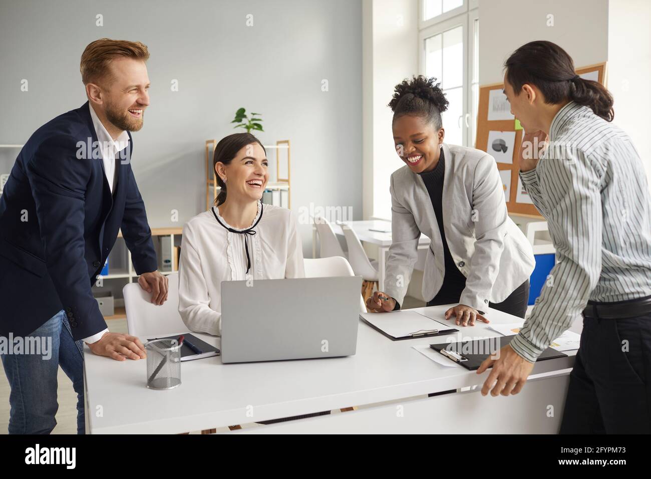 Group of happy young diverse business people talking, sharing funny ideas and laughing Stock Photo
