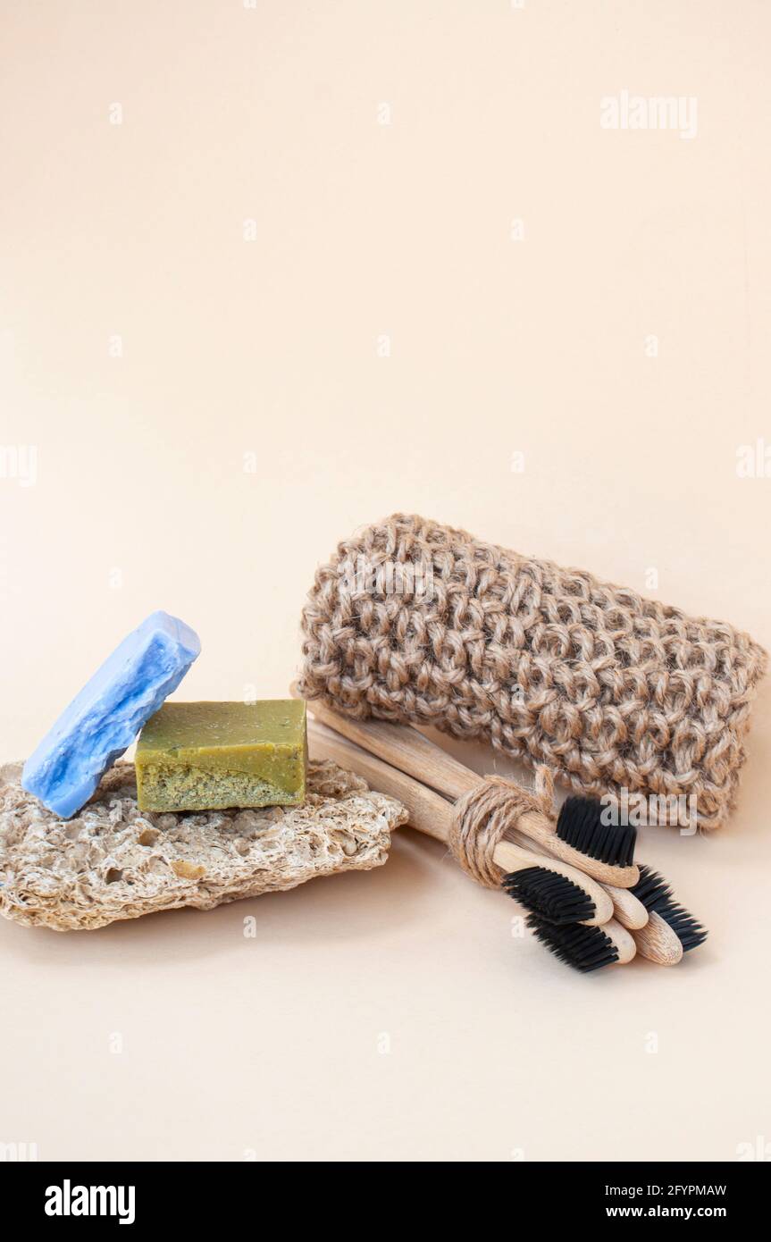 Zero waste bathroom accessories - toothbrushes, natural soap and knit twine scrubber on a beige background. Sustainable lifestyle concept. Stock Photo