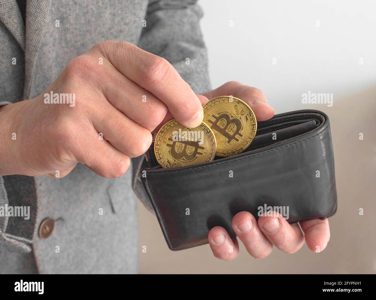 Businessman wearing a suit, holding a wallet and Bitcoin BTC crypto  currency gold coins, new virtual money concept. Mining or blockchain  technology Stock Photo - Alamy