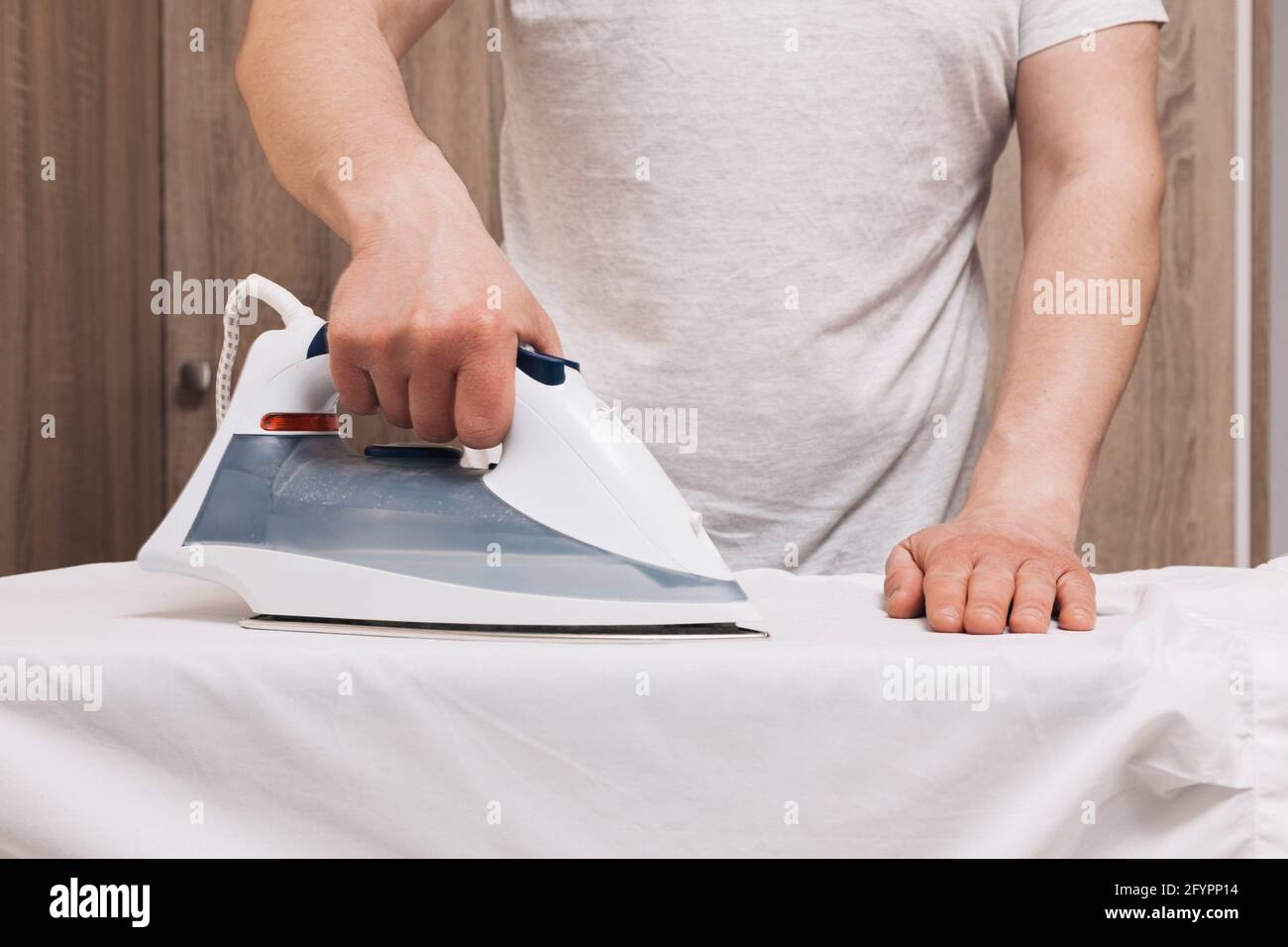 Man ironing clothes hi-res stock photography and images - Alamy