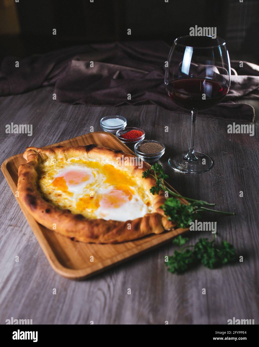 flatbread with yam and cheese in the restaurant. Dish with wine and herbs Stock Photo