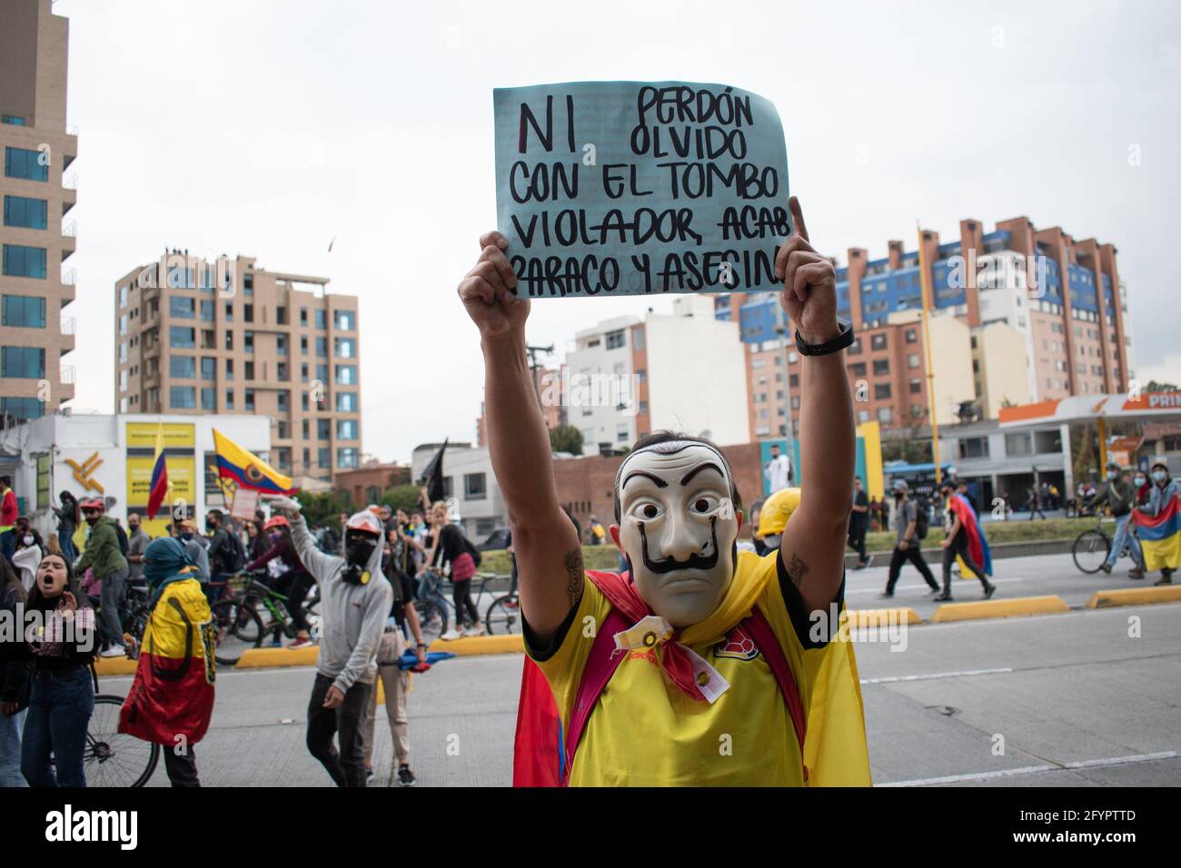 Bogota, Cundinamarca, Colombia. 28th May, 2021. A protester holds a sign that reads: ''Neither forgive nor forget for the murderous policeman, rapist and maramilitar'' in a new day of protests in BogotÃ¡ in the context of the commemoration of a month of the start of the national strike in Colombia against the Government of IvÃ¡n Duque, on March 28, 2021. Credit: Daniel Romero/LongVisual/ZUMA Wire/Alamy Live News Stock Photo