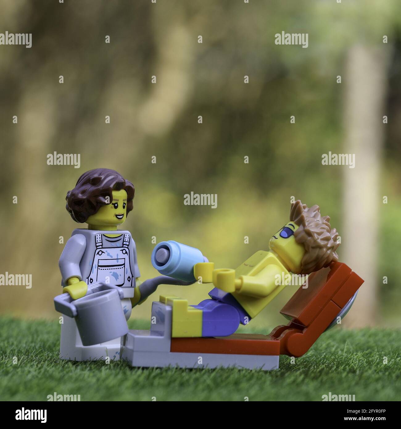 LUTON, UNITED KINGDOM - May 20, 2020: Trying to relax in the sun but needs to do work as represented with Lego figures Stock Photo