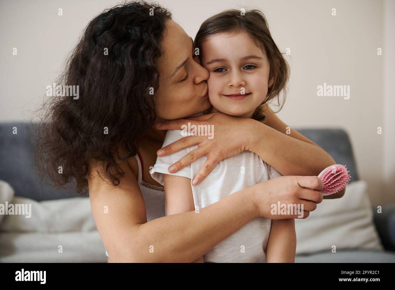 Beautiful baby girl feels happy when her loving mother hugging and