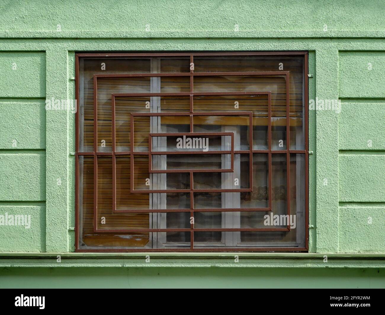 Window with an iron grid on a green wall Stock Photo - Alamy